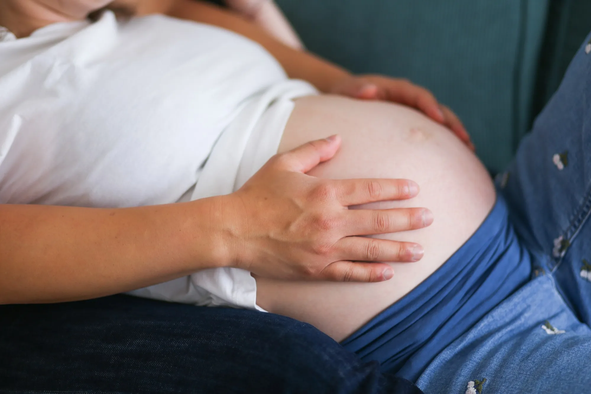 Solène enceinte, assise sur un canapé
